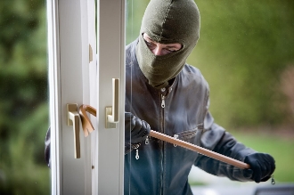 Burglar breaking into house with crowbar.