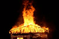 A view of a burning house in the dark
